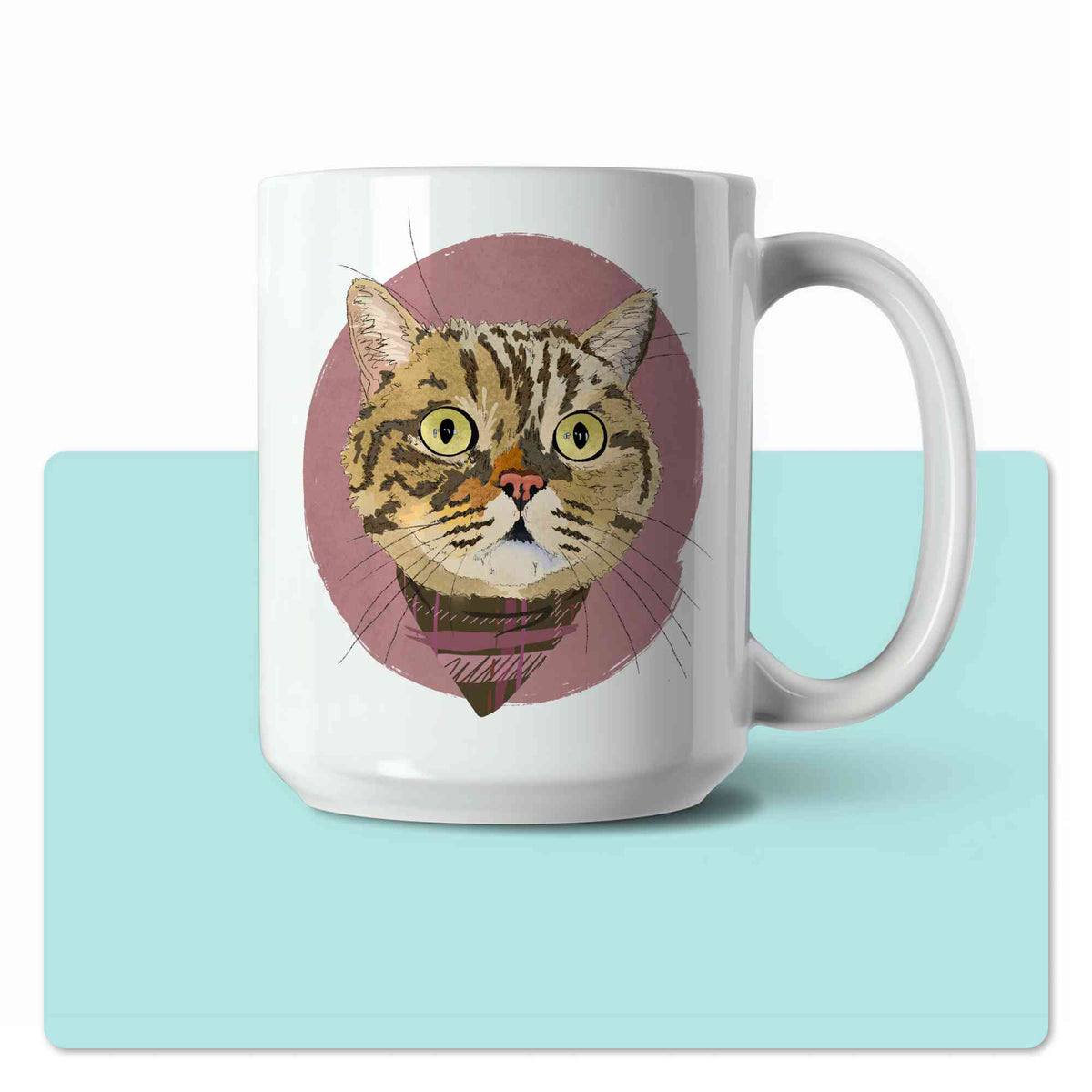 A white ceramic coffee mug featuring a custom illustrated cat portrait of a tabby cat wearing a plaid bandana set against a subtle textured dusty rose circular background printed on the side of the mug, shown centered over a large light aqua rectangular shape on a white background.