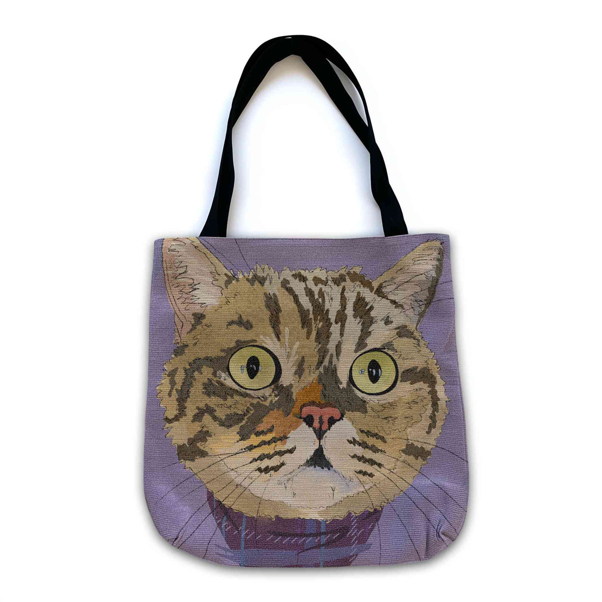 A woven tote bag with black shoulder straps featuring a custom illustrated cat portrait of a tabby cat wearing a plaid bandana set against a subtle textured lavender background printed on the side of the bag, shown on a clean white background. 